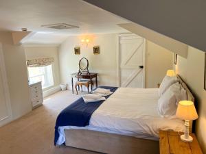 a bedroom with a bed and a desk and a window at Kirk House Longtown in Longtown