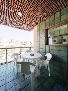een eetkamer met een tafel en stoelen op een balkon bij IPF2045C - Tiffany's Residence Service - Ipanema in Rio de Janeiro