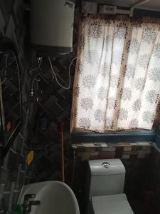 a bathroom with a toilet and a window with snowmen at Lebong Mansara Homestay in Darjeeling +23 photos