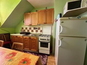 a kitchen with a white refrigerator and wooden cabinets at Privát Mulík in Stará Lesná