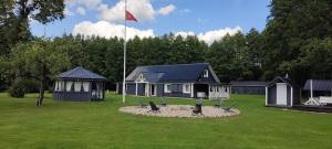 a house with a flag in front of a yard at Perlytė in Metelyte +28 photos