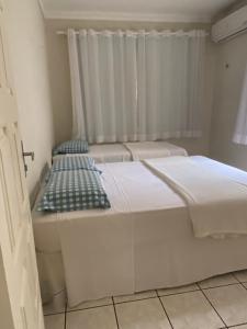 due letti in una stanza con finestra di Casa Sol-ampla com piscina no coração de Gostoso a São Miguel do Gostoso
