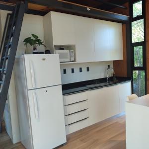 a kitchen with white cabinets and a white refrigerator at Tokai Surubi'i in Colonia Mariano Roque Alonso
