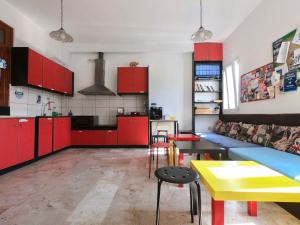 a living room with red cabinets and a yellow table at Fira Backpackers Place in Fira