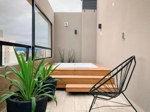 Habitación con cama, silla y plantas en Smart AirLoft - Salta, en Salta