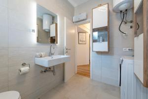 een badkamer met een wastafel en een spiegel bij Apartment Dora family only in Vodice +30 foto's