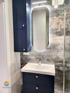 a bathroom with a sink and a mirror at Sztutowo Perła Mierzei by Grand Apartments in Sztutowo