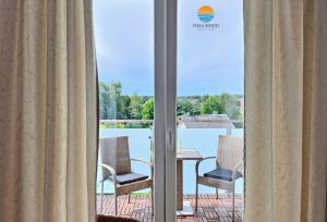 a room with a view of a patio with chairs and a table at Sztutowo Perła Mierzei by Grand Apartments in Sztutowo