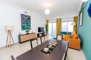 ein Wohnzimmer mit Tisch und Couch in der Unterkunft Charmant appartement 2ch près de la plage in Pointe-Noire