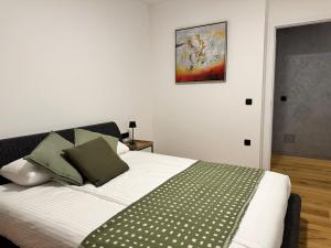 a bedroom with a bed with a green and white blanket at Lux Apartment in Bovec