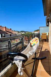 Una silla en un balcón con vista al mar. en Precioso ático con amplia terraza, en Portonovo