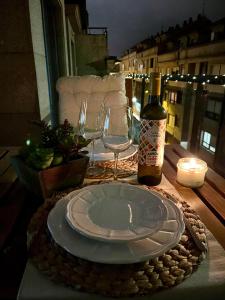 una mesa con un plato y una botella de vino en Precioso ático con amplia terraza, en Portonovo