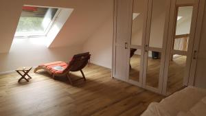 a room with a chair and a table and a window at Naturferienhof Märkisch Luch - Trapphahn in Nennhausen