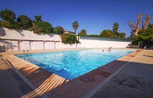 a large swimming pool with people in the water at Léman Holidays - Le Palm in Mandelieu-La Napoule