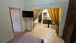 a room with a bed and a television and a kitchen at Sweet Dreams #4 in Coco