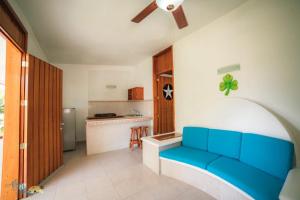 a blue couch in a room with a kitchen at Hotel Altos Paraiso in Piedra Blanca