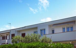 a white building with trees in front of it at Nice Apartment In Isola Di Capo Rizzuto in Ovile la Marinella