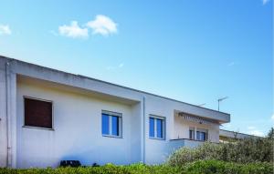 a white building with windows on the side of it at Nice Apartment In Isola Di Capo Rizzuto in Ovile la Marinella +10 photos
