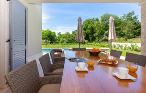une salle à manger avec une table et des chaises et une piscine dans l'établissement 3 Bedroom Awesome Home In Nedescina, à Nedeščina