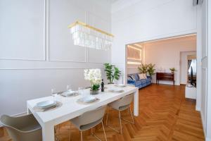 a white dining room with a white table and chairs at Servi Deluxe Apartament in Florence