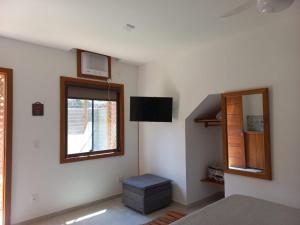 a bedroom with a bed and a window at Encanto da Serra Suítes Lumiar in Lumiar