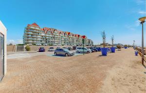 a parking lot with cars parked in front of a building at Seaside Studio in Cucq