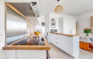 a kitchen with white cabinets and a stainless steel refrigerator at Seaside Studio in Cucq