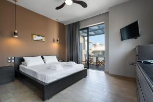 a bedroom with a large bed and a television at Villa Cicada Chania, steps from the beach, Car included in Agia Marina Nea Kydonias