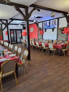 a dining room with tables and chairs with red tablecloths at Комплекс Тракийски стан in Asenovgrad