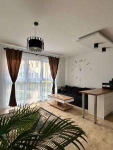 een woonkamer met een bank en een klok aan de muur bij Apartamenty Zielona in Zielona Góra