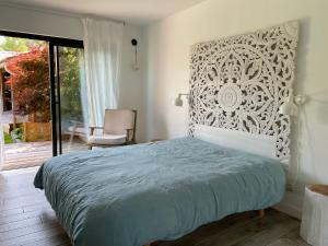 ein Schlafzimmer mit einem Bett, einem Fenster und einem Stuhl in der Unterkunft Villa 7 in Le Moutchic