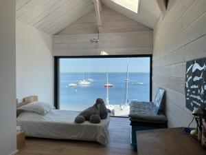 ein Teddybär auf einem Bett in einem Zimmer mit Fenster in der Unterkunft Villa 7 in Le Moutchic + 3 Fotos