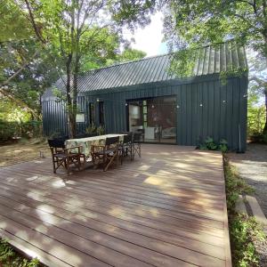 a wooden deck with a table and chairs on it at Tokai Surubi'i in Colonia Mariano Roque Alonso