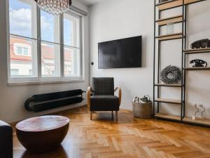 a living room with a tv and a chair and a table at Funkcional Apartment in Brno