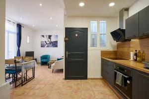 una cucina con porta nera e una sala da pranzo di Le Cabrit - Climatisation - Wifi a Perpignano Altre 32 foto