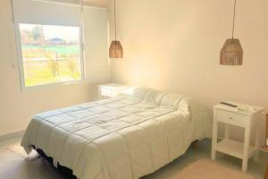 una camera da letto bianca con un letto e una finestra di Casa Quinta Gardey a Gardey