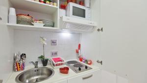 a small kitchen with a sink and a microwave at Rental in Rome Colosseo Loft in Rome