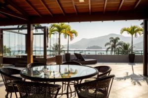 a patio with a glass table and chairs at Sintonia com o Mar in Angra dos Reis +29 photos