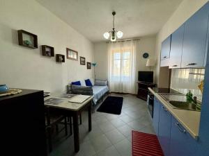 a kitchen and living room with a table and a couch at monolocale Antica Argenteria stazione e centro a due passi in Vercelli