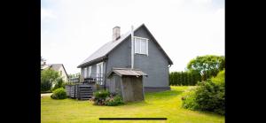 a gray house with a small shed in the yard at Divstavu maja Gulbene in Gulbene