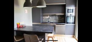 a kitchen with a black counter top and a sink at Divstavu maja Gulbene in Gulbene +8 photos
