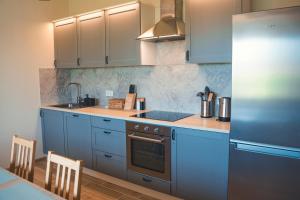a kitchen with blue cabinets and a sink and a stove at Garden View Apartment in Cēsis