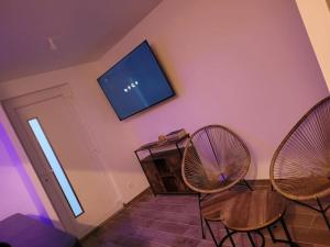 a living room with two chairs and a flat screen tv at Maison cosy avec jacuzzi in Thourotte