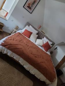 a bedroom with a bed with red and white pillows at Maison cosy avec jacuzzi in Thourotte
