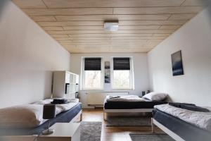 a room with two beds and two windows at Preiswerte Apartments für Monteure, WLAN, Smart-TV & kostenfreie Parkplätze in Neupetershain