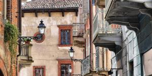 a building with two street lights on the side of it at monolocale Antica Argenteria stazione e centro a due passi in Vercelli