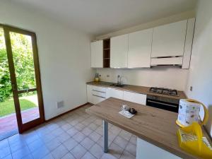 a kitchen with white cabinets and a wooden table at Villino Cocca in Marina di Massa +5 photos