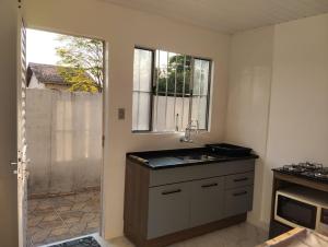 a kitchen with a sink and a window at Lar Aconchego in Mogi das Cruzes