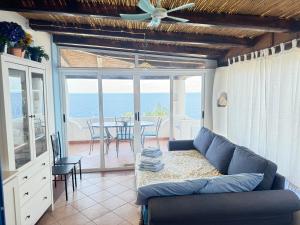 a living room with a couch and a table with chairs at La Casuzza Dei Re in Malfa