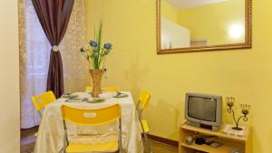 ローマにあるRental in Rome Sardegna Apartmentの黄色のダイニングルーム(テーブル、テレビ付)